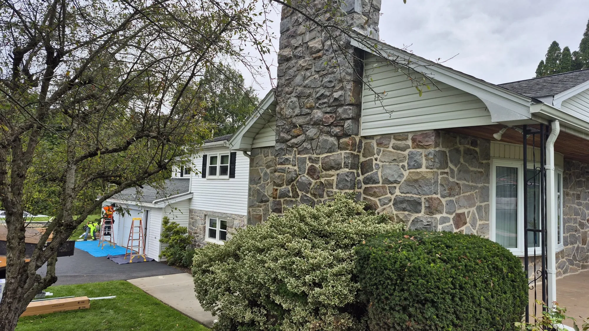Stone chimney and white siding during exterior improvements