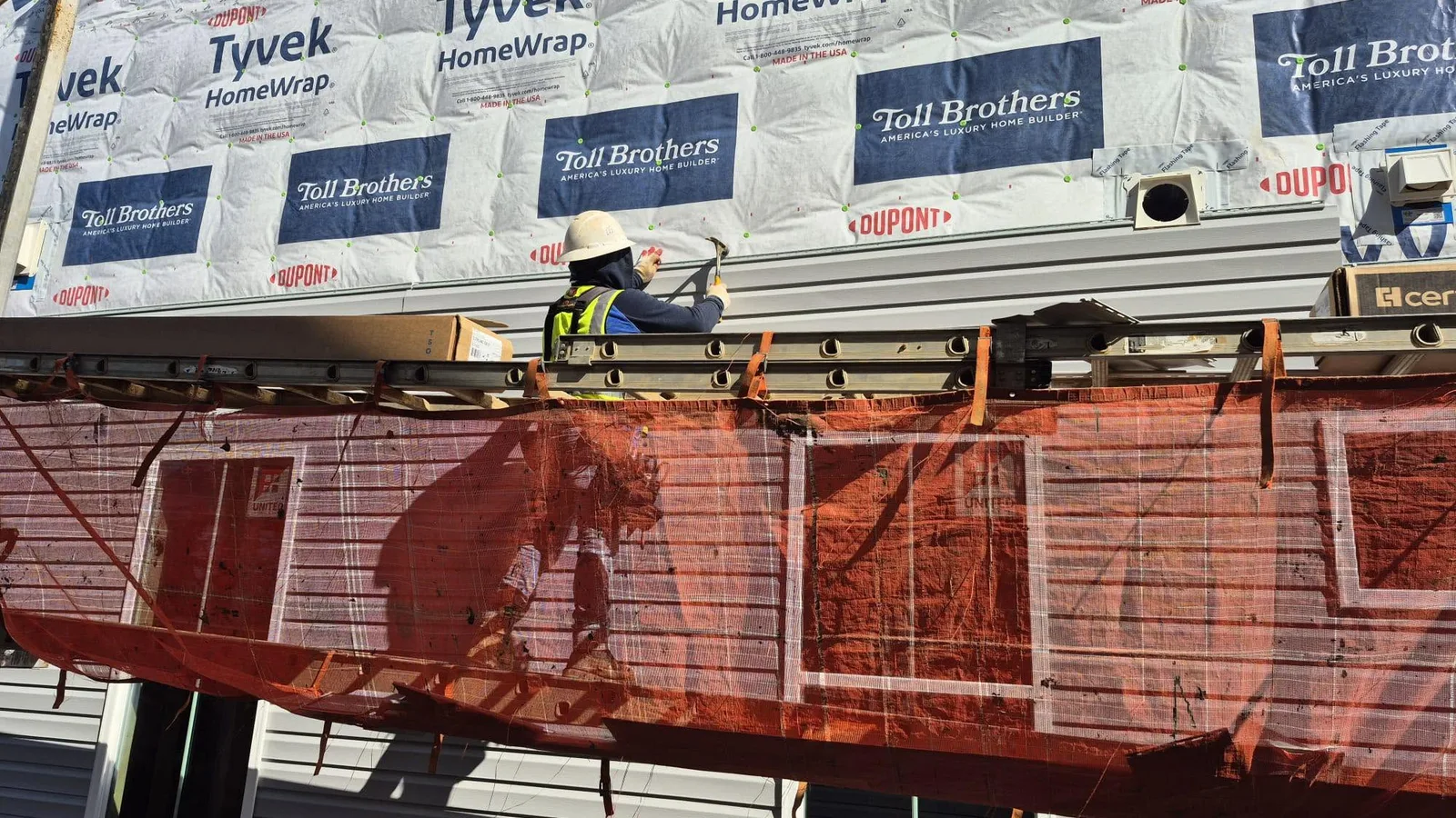 Worker installing horizontal siding on a home